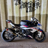 Motorcycle parked on a concrete surface with a corrugated metal wall in the background