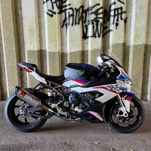 Load image into Gallery viewer, Motorcycle parked on a concrete surface with a corrugated metal wall in the background
