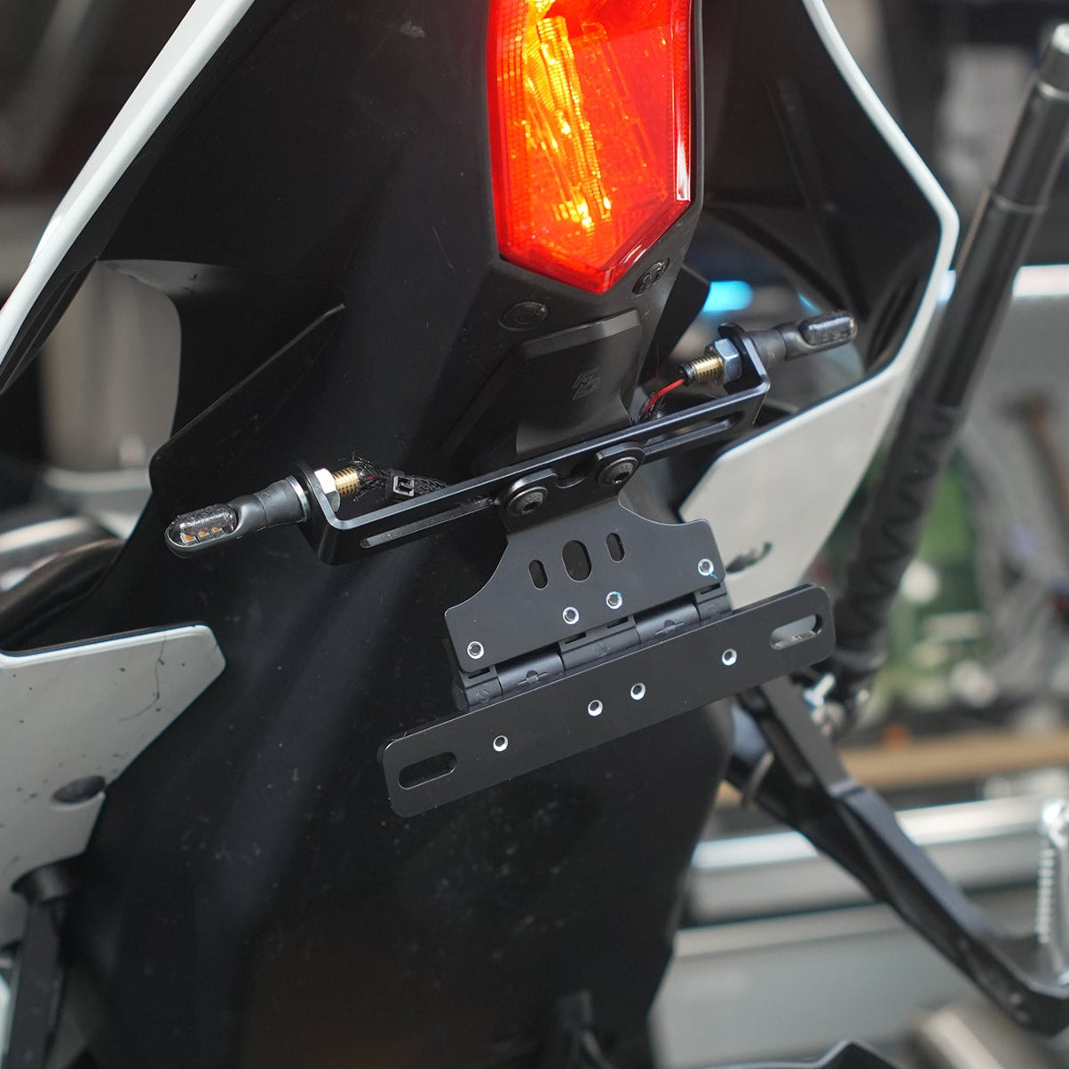 Close-up of a motorcycle's taillight in a garage setting